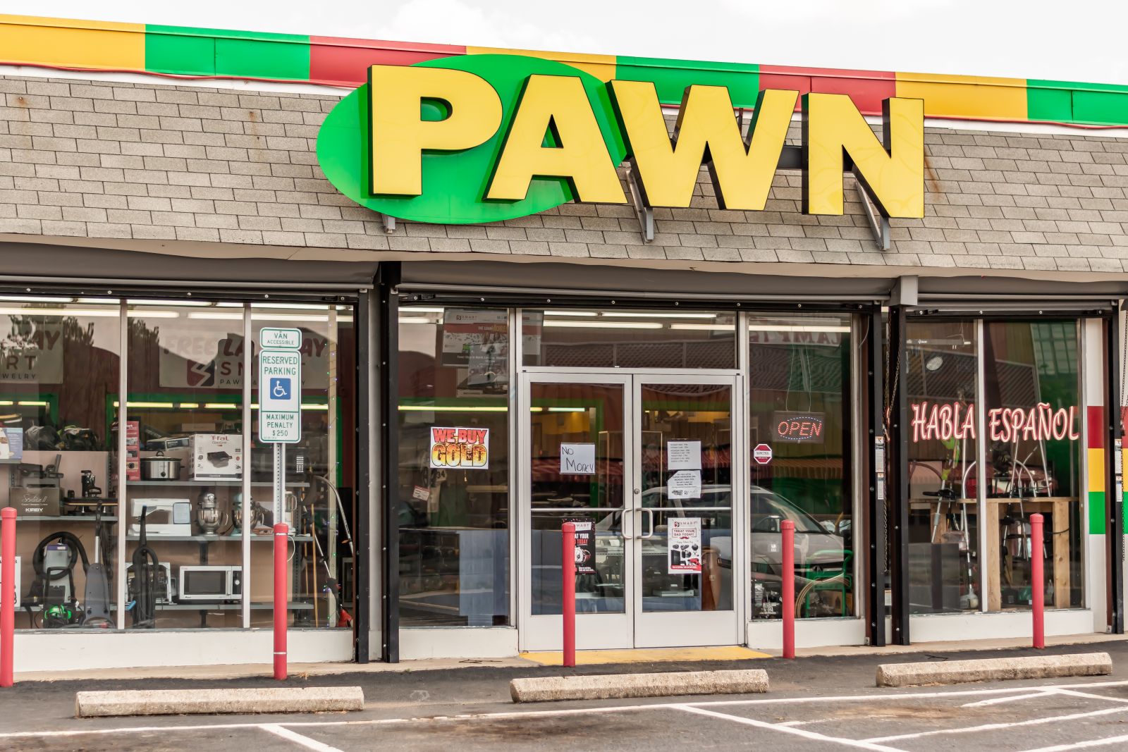 The front of a pawn store with a green and yellow sign by Bruce VanLoon via Shutterstock