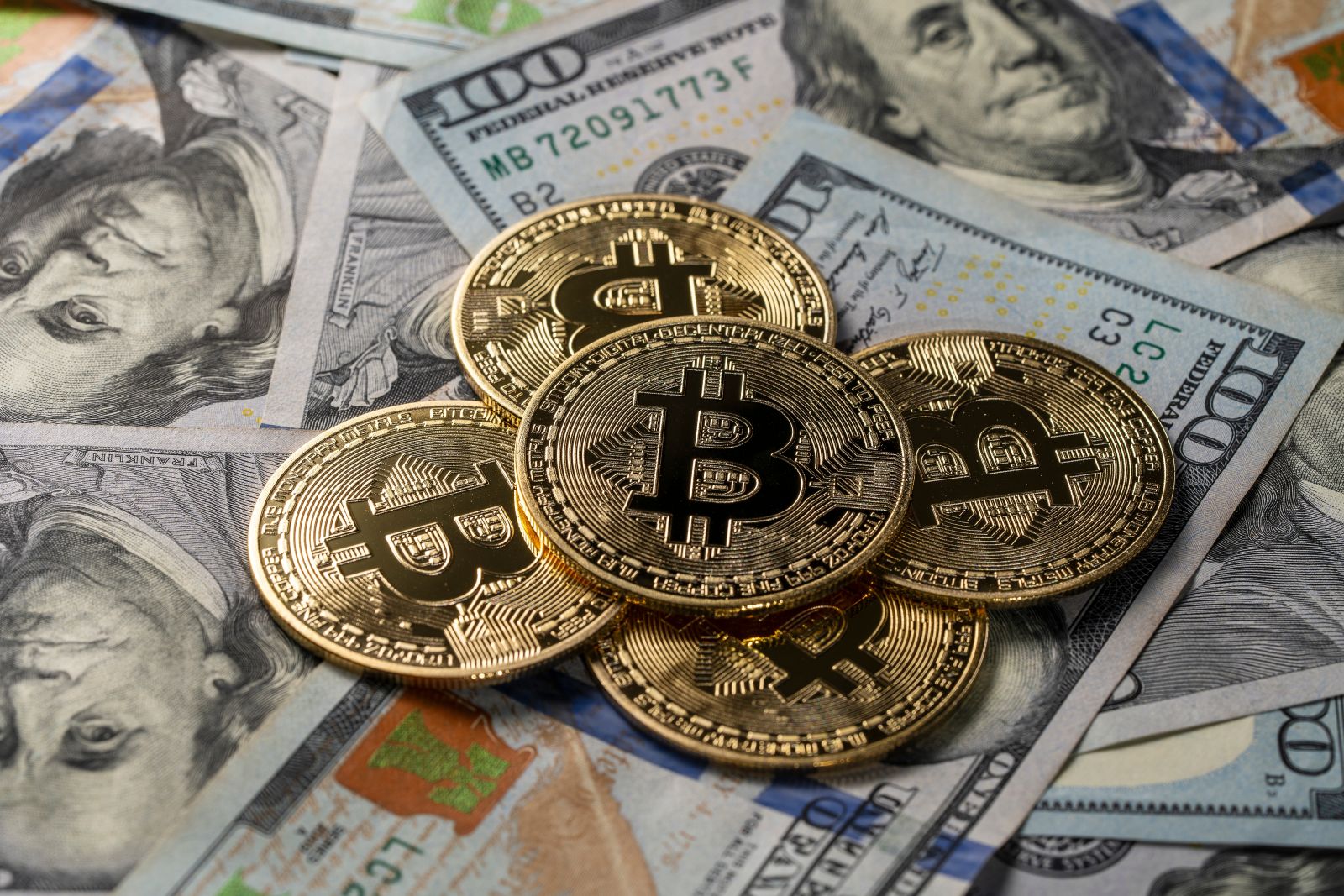 Bitcoin and hundred dollar bills via Shutterstock