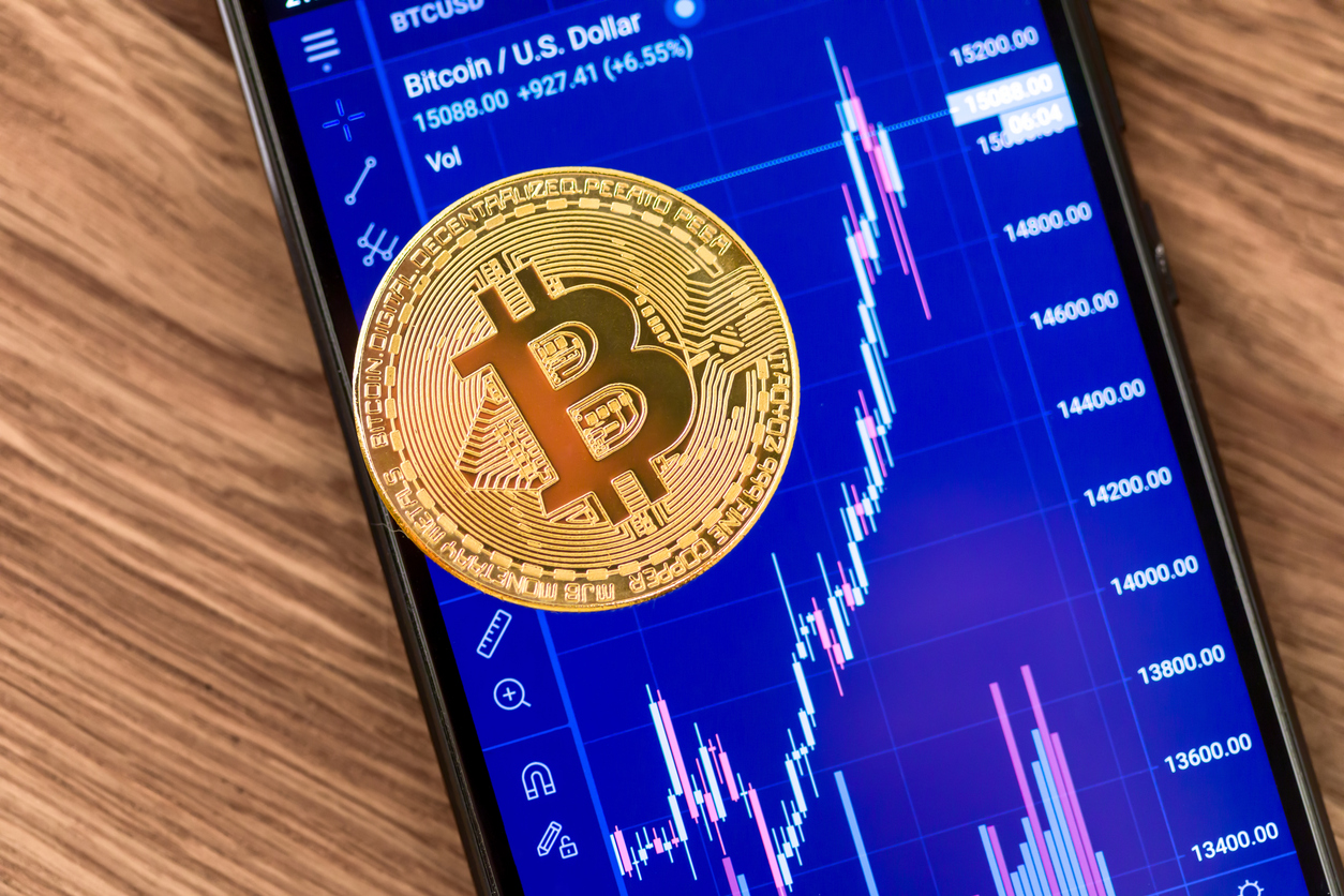 Crypto - Bitcoin on phone stock prices background by Vadim Volodin via iStock