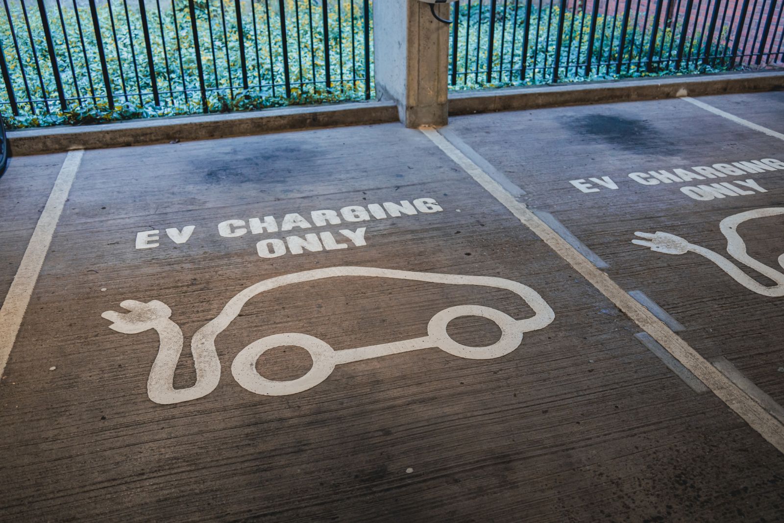 Green Energy (EV, solar, etc.) - electric car charging parking spot by Adam Webb via iStock