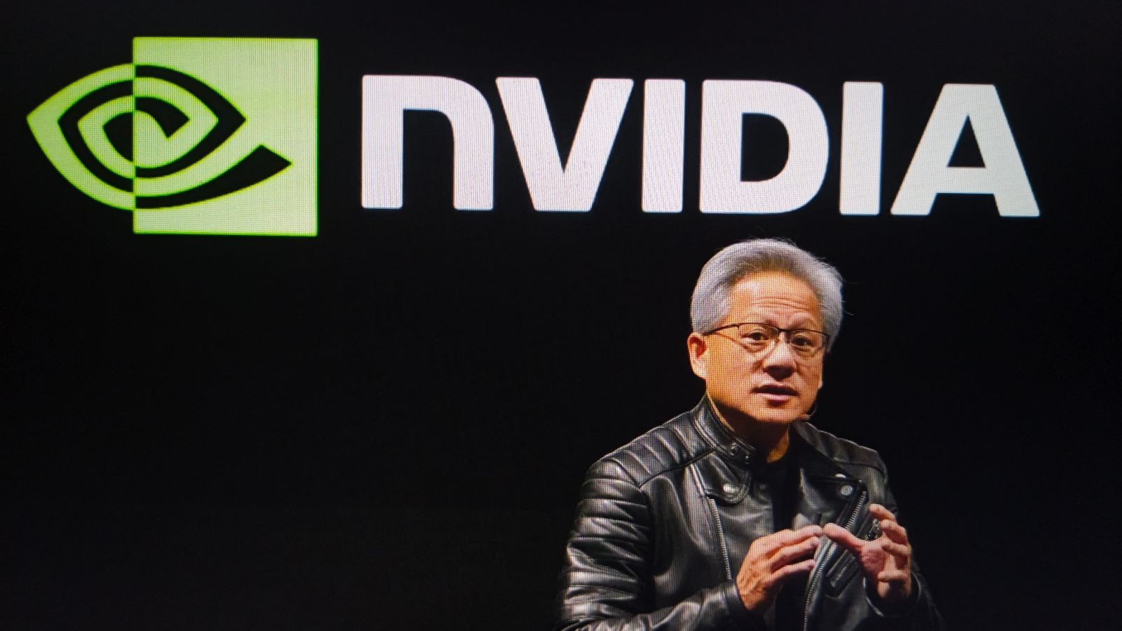 A photo of CEO Jensen Huang in front of the Nvidia logo by FotoField via Shutterstock