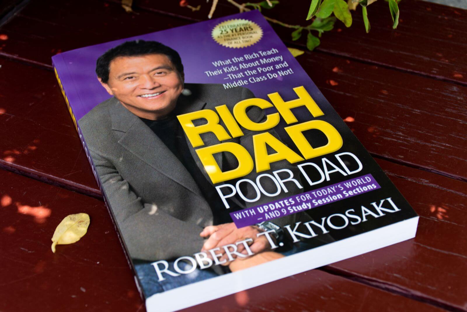 Dubai, UAE - May 19, 2024 Close-up of Robert Kiyosaki and Sharon Lechter's Rich Dad Poor Dad book on a wooden table by Hamdi Bendali