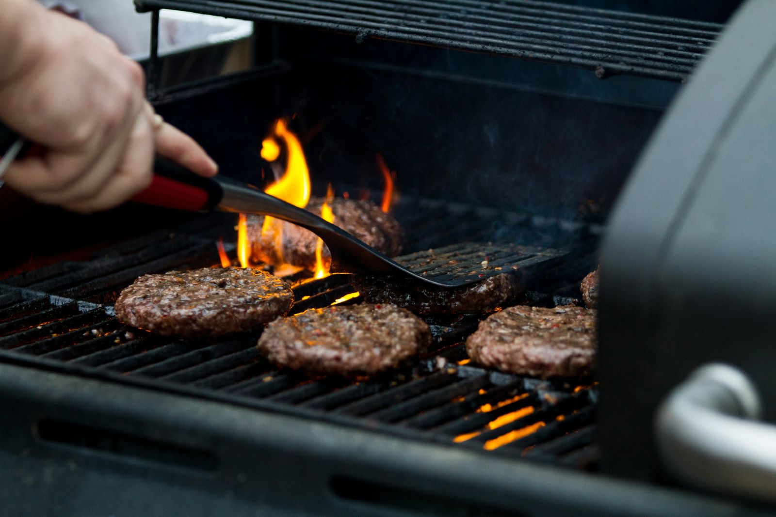 Person grilling burger patties by Zac Cain via Unsplash