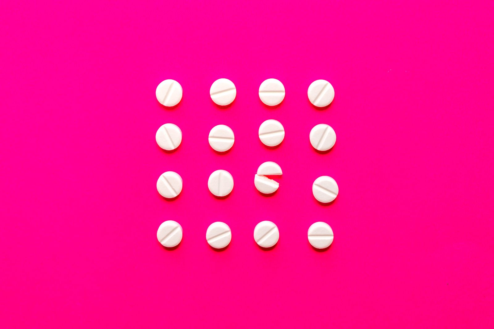 Healthcare - White tablets on pink background by Jose Antonio Luque Olemedo via iStock