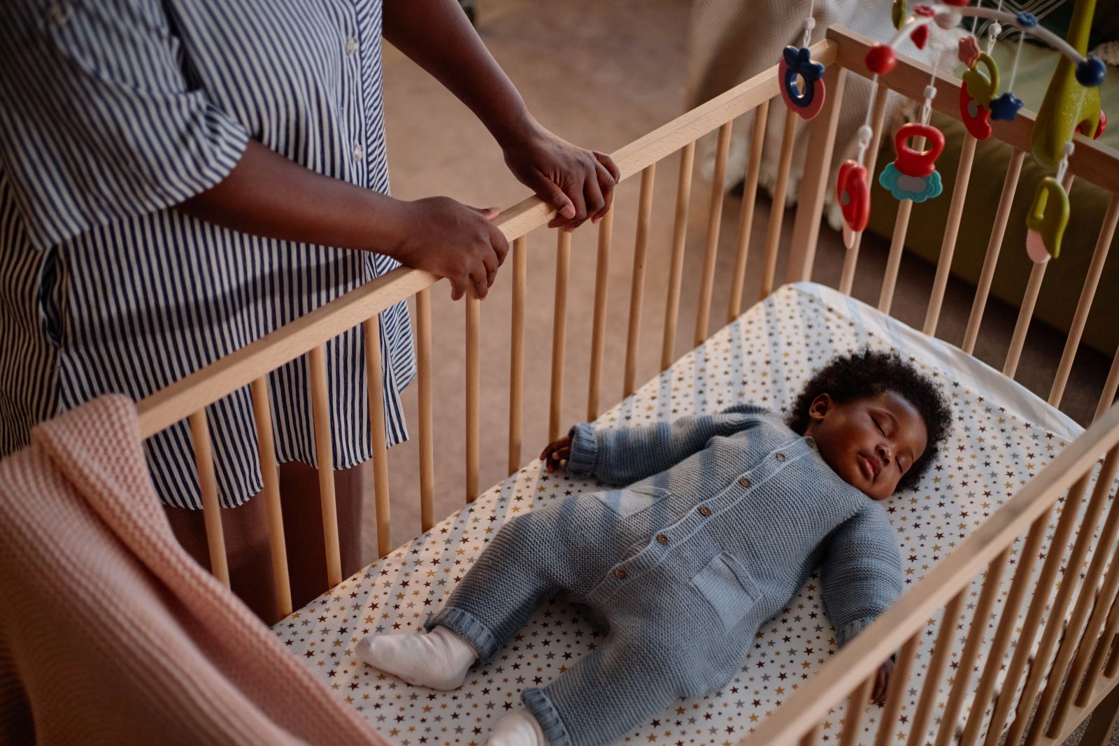 A baby sleeping in a crib by SeventyFour via Shutterstock