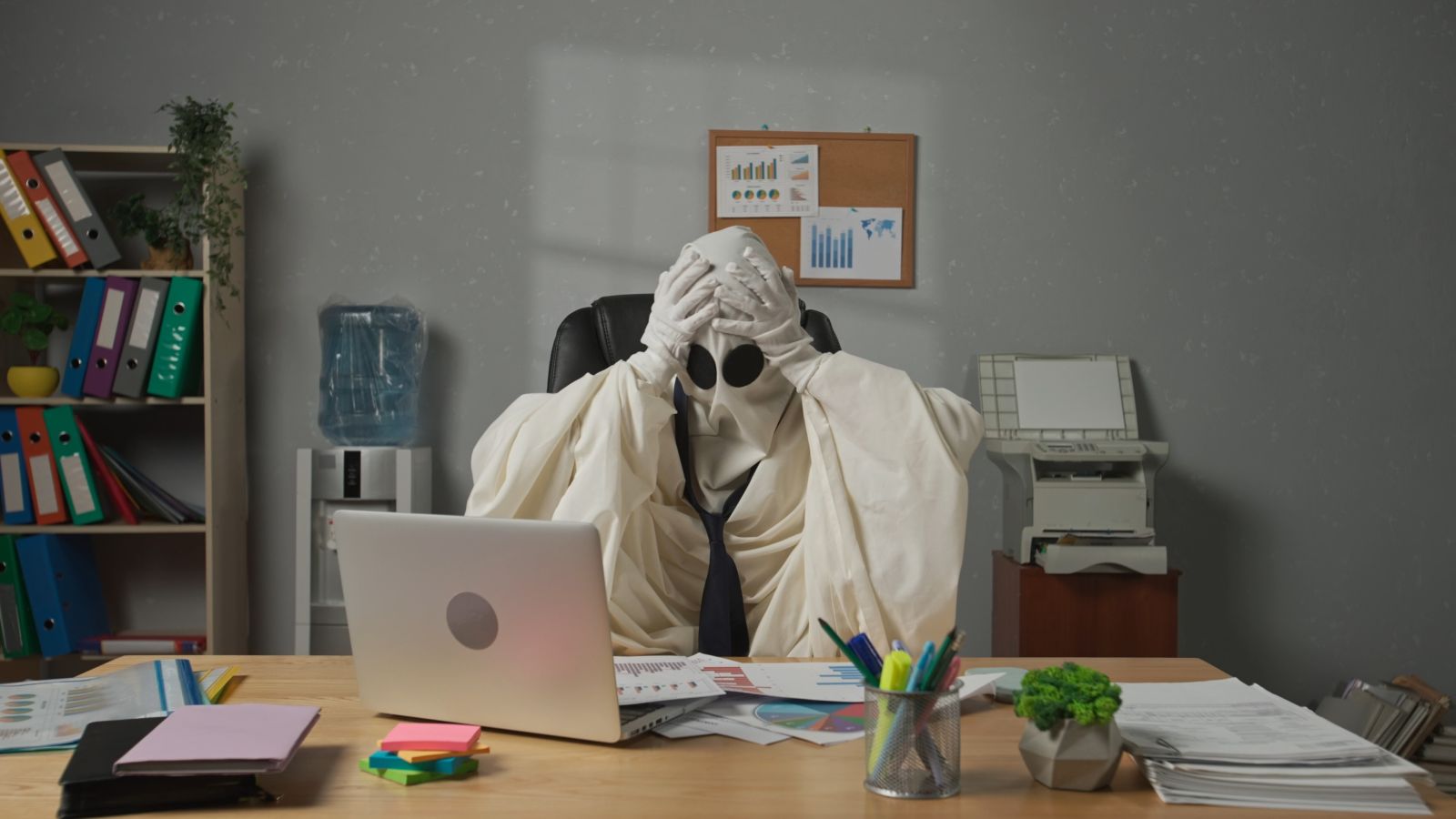 A concept image of a ghost businessman sitting at his desk by kinomaster via Adobe Stock
