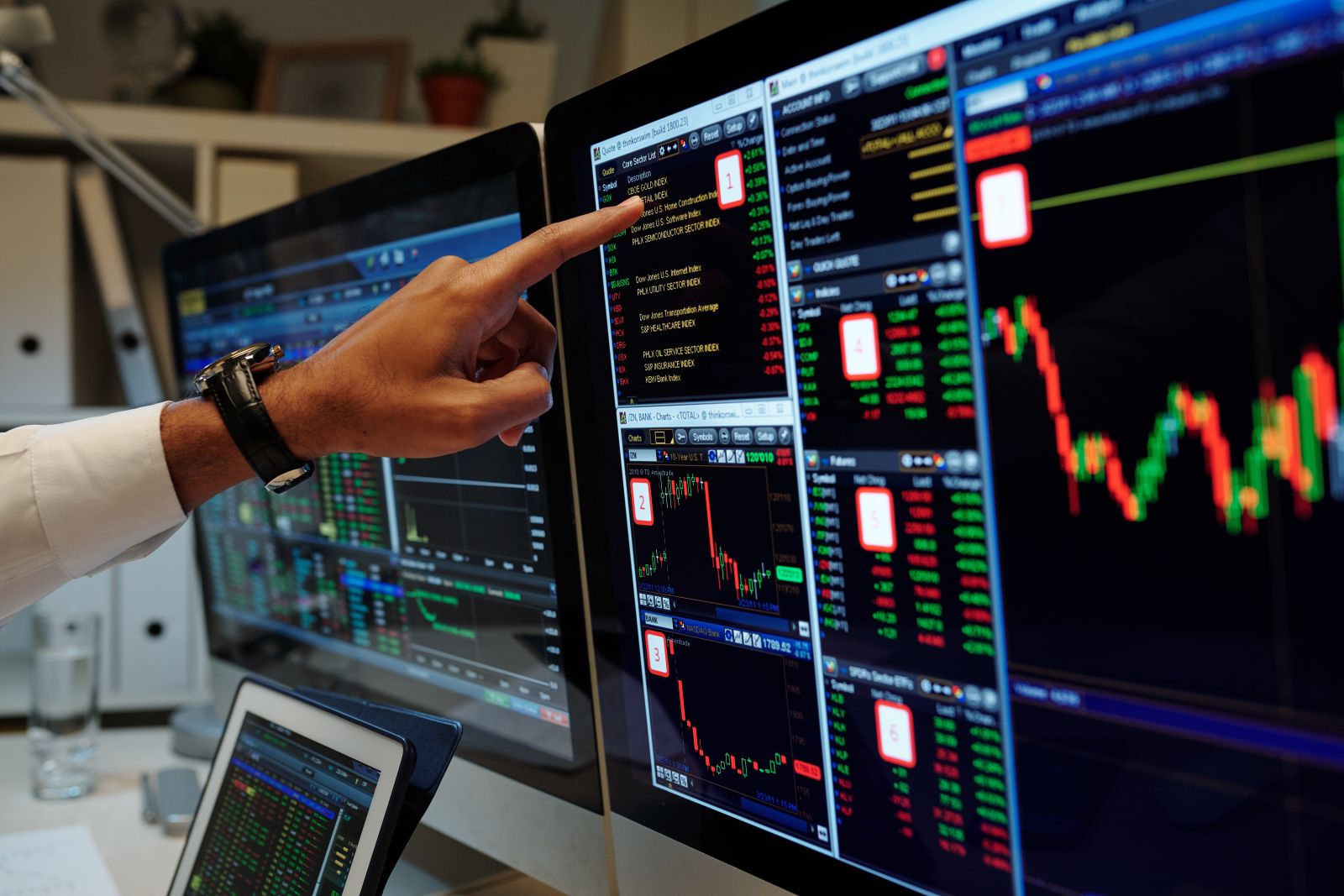 Trader pointing at stock market graphs by DragonImages via Adobe Stock