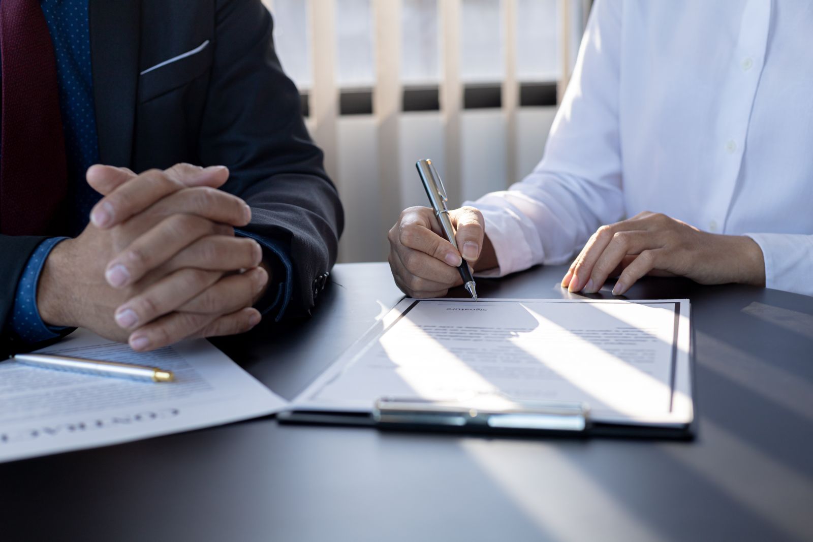 Insurance salesman and customer signing agreement by kamiphotos via Adobe Stock