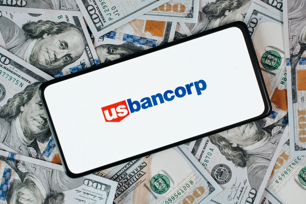 Financial (names J - Z) - U_S_ Bancorp_ logo on phone with money background-by Sergio Photone via Shutterstock