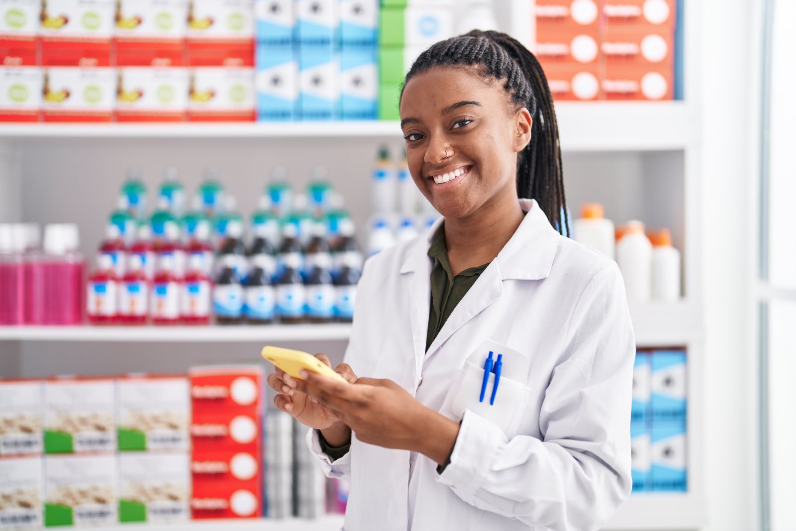 African american woman pharmacist using smartphone in pharmacy by Krakenimages_com via Adobe Stock