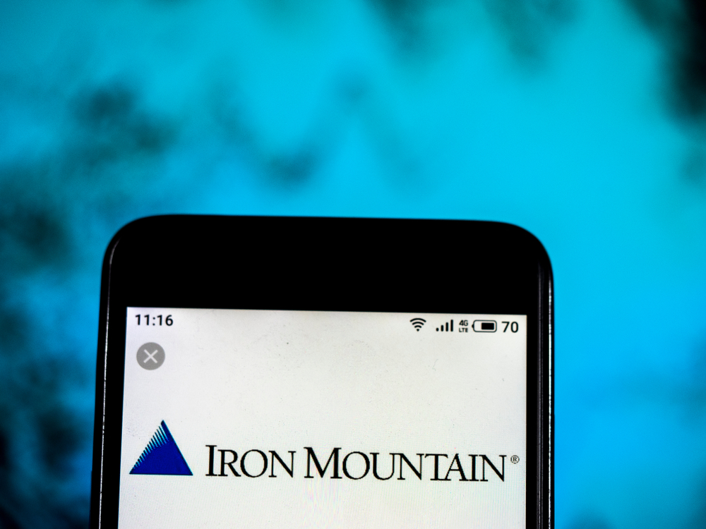 Real Estate - Iron Mountain Inc_ logo on phone-by IgorGolovniov via Shutterstock