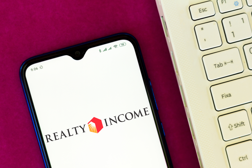 Real Estate - Realty Income Corp_ logo on phone with keyboard-by rafapress via Shutterstock