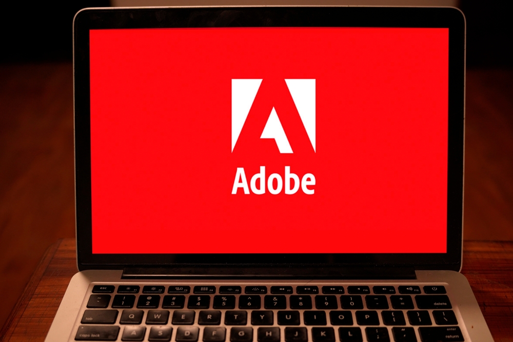 Technology (names A - I) - Adobe Inc logo on computer-by DANIEL CONSTANTE via Shutterstock