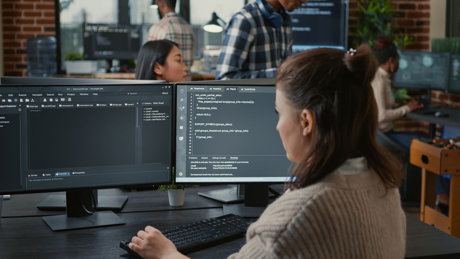 Software programmer writing code in front of multiple computer screens with AI algorithm by DC Studio via Adobe Stock