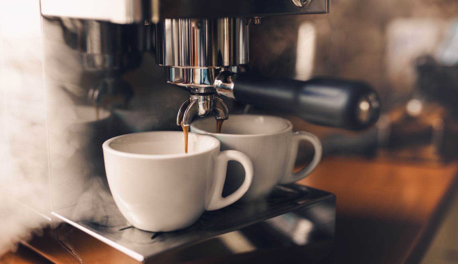 Espresso machine filling cups of coffee by Bastian Weltjen via iStock