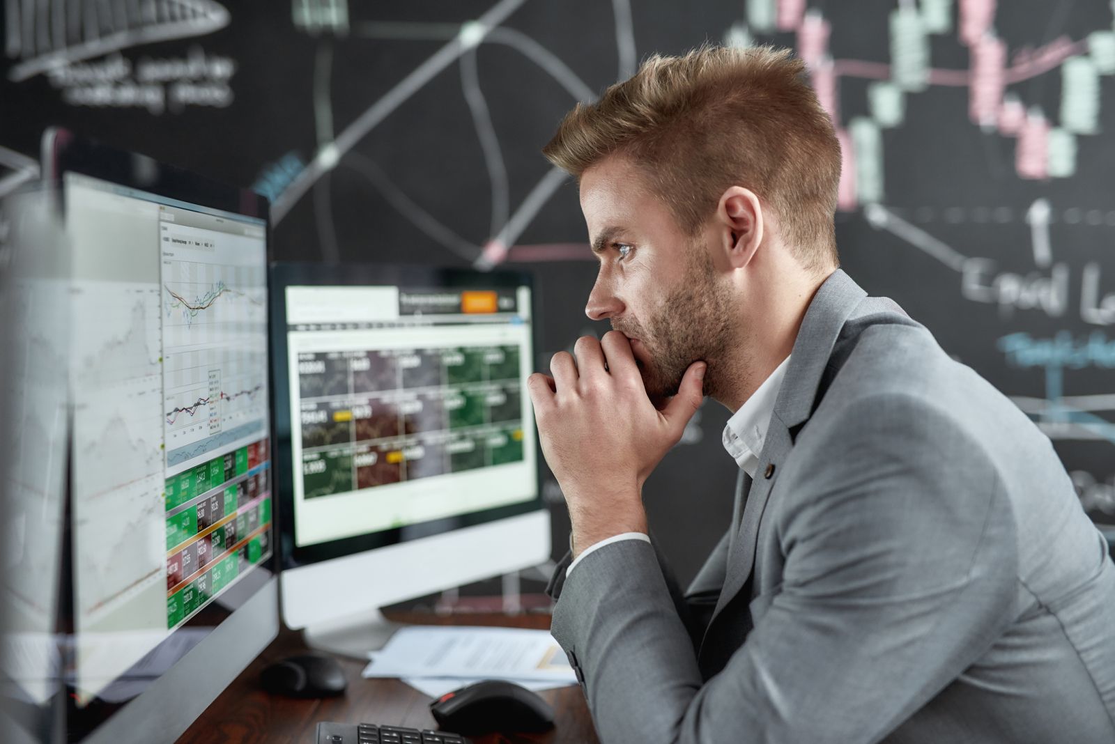 Charts, tickers, traders - Desk setup looking at stocks by LanaStock via iStock