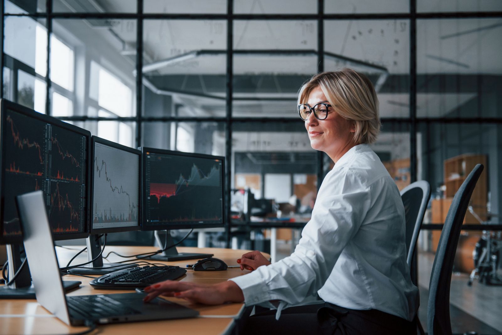 Charts, tickers, traders - Female stockbroker by Standret via iStock