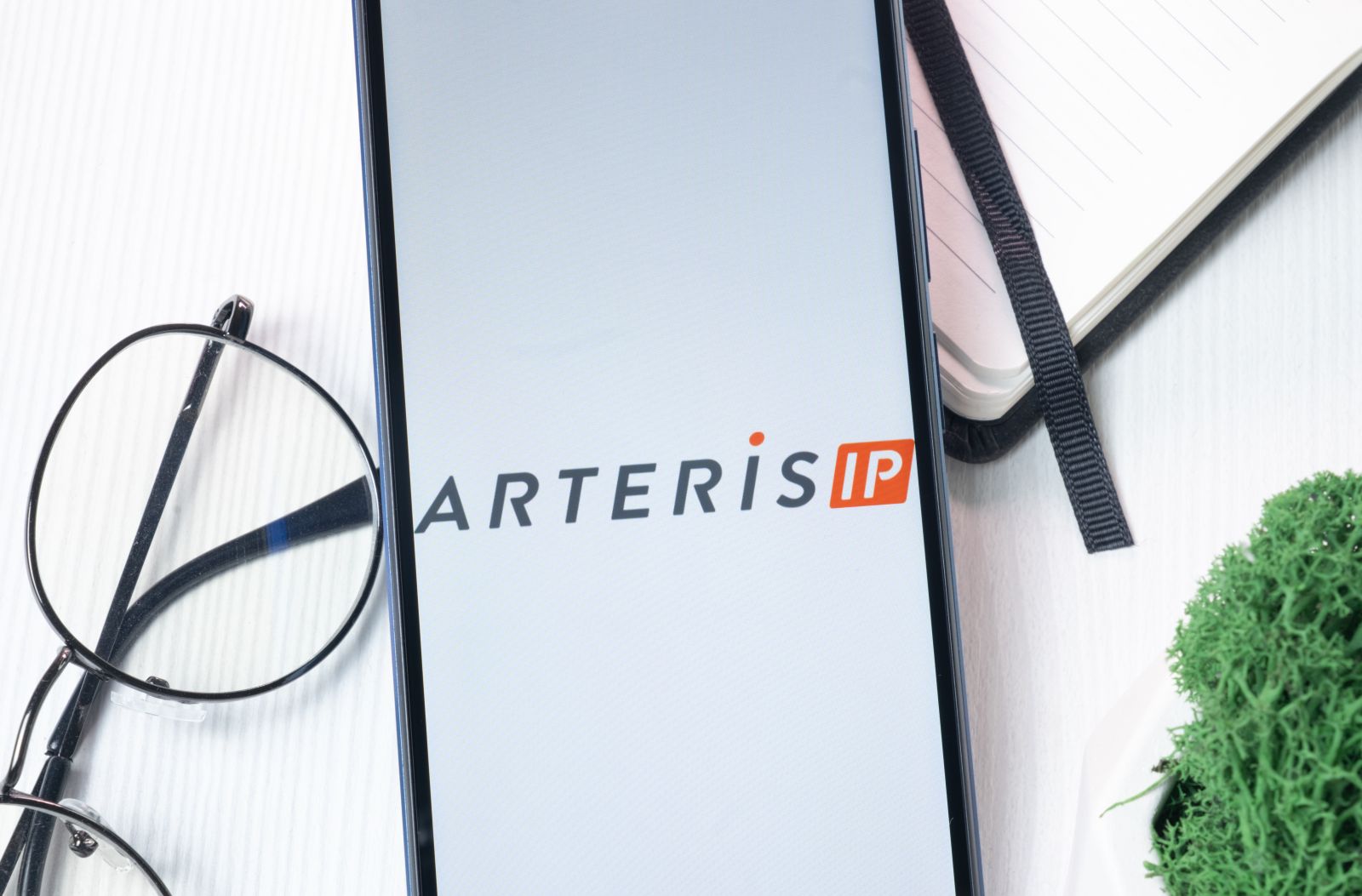 The Arteris logo displayed on a smartphone screen by Postmodern Studio via Adobe Stock
