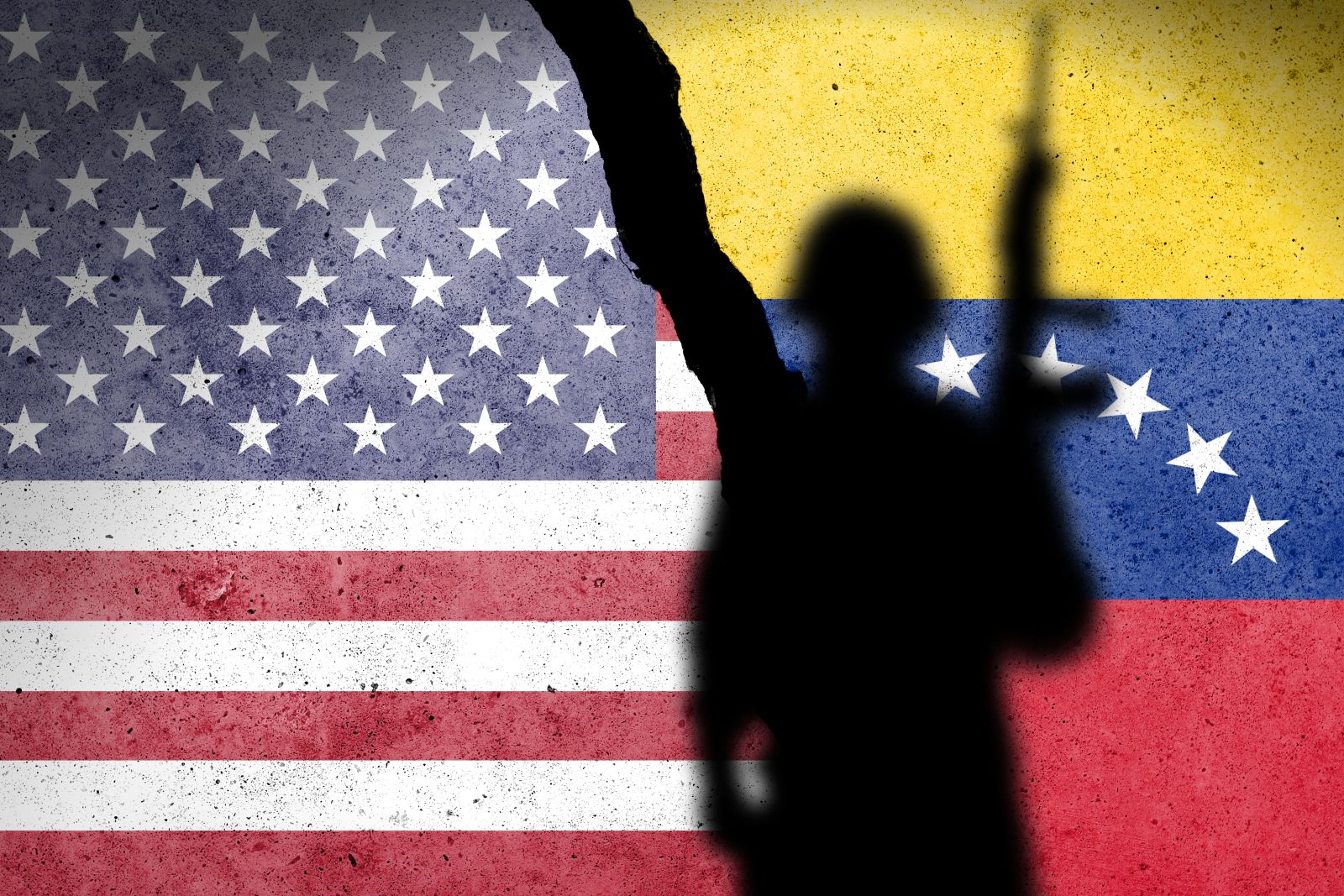 Flag of USA and Venezuela painted on a concrete wall with soldier's shadow_ Image by Tomas Ragina via Shutterstock_