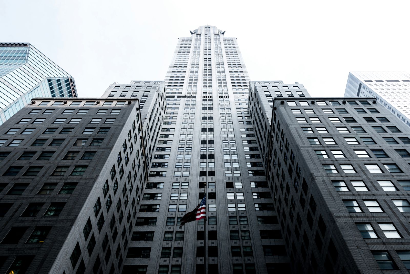 Wall Street - Loooking up a tall building in NYC by Andres Garcia via Unsplash