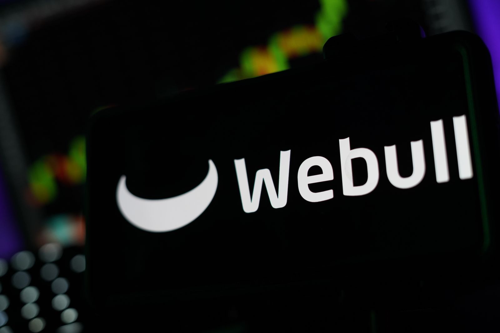 The Webull logo displayed on a phone screen by PJ McDonnell via Shutterstock