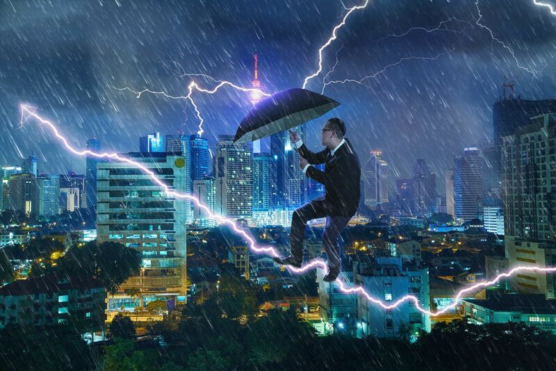 Weather - businessman-with-umbrella-against-thunderstorm-overcoming-challenge-SBI-301985594